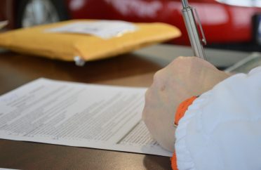 Photo of hand of business person signing a business finance agreement