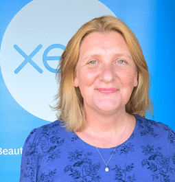 Photo of Lucy Deasy, management accountant, taken in front of a Xero beautiful accounting banner